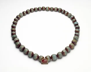 Cilindro de fayenza y collar con colgante de oro, turquesa y cornalina en forma de anillo shen, el signo de la eternidad